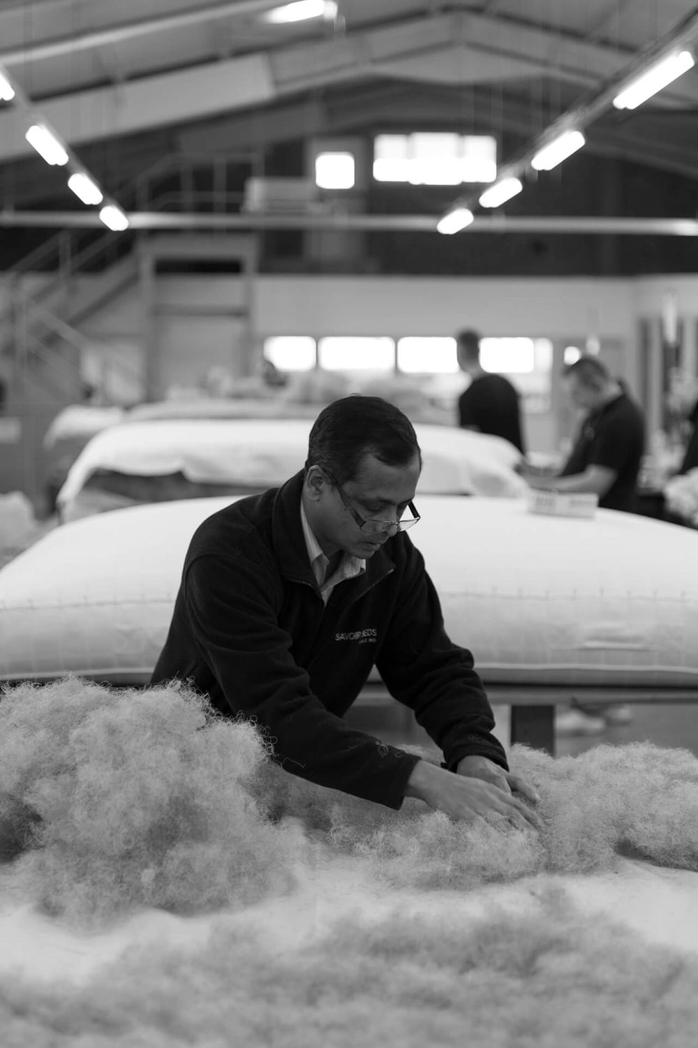 Photograph of a Savoir Beds craftsmen making one of the custom size beds