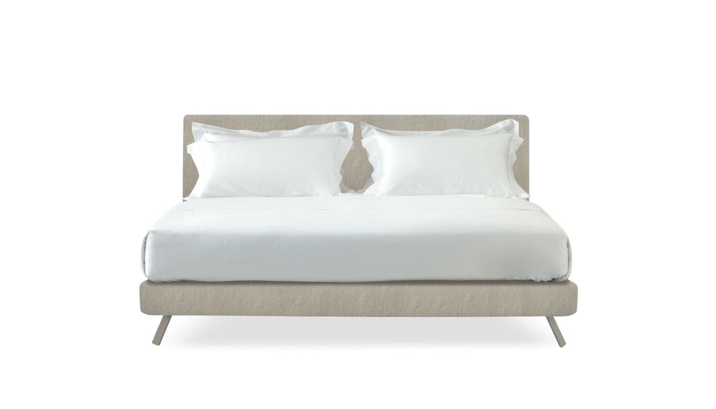 Beige bed with white bedding and pillows on a white background