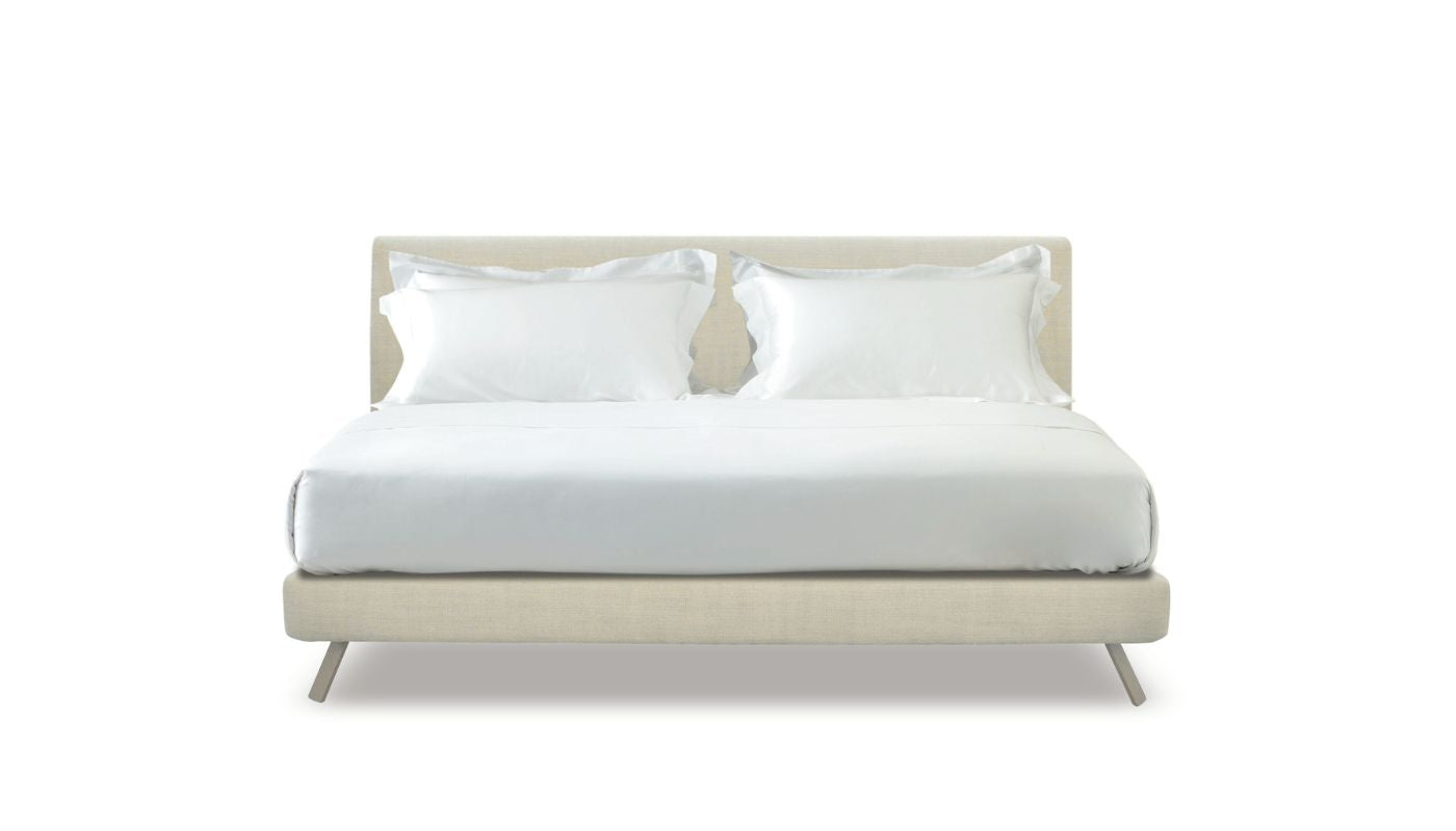 Beige bed with white bedding on a white background