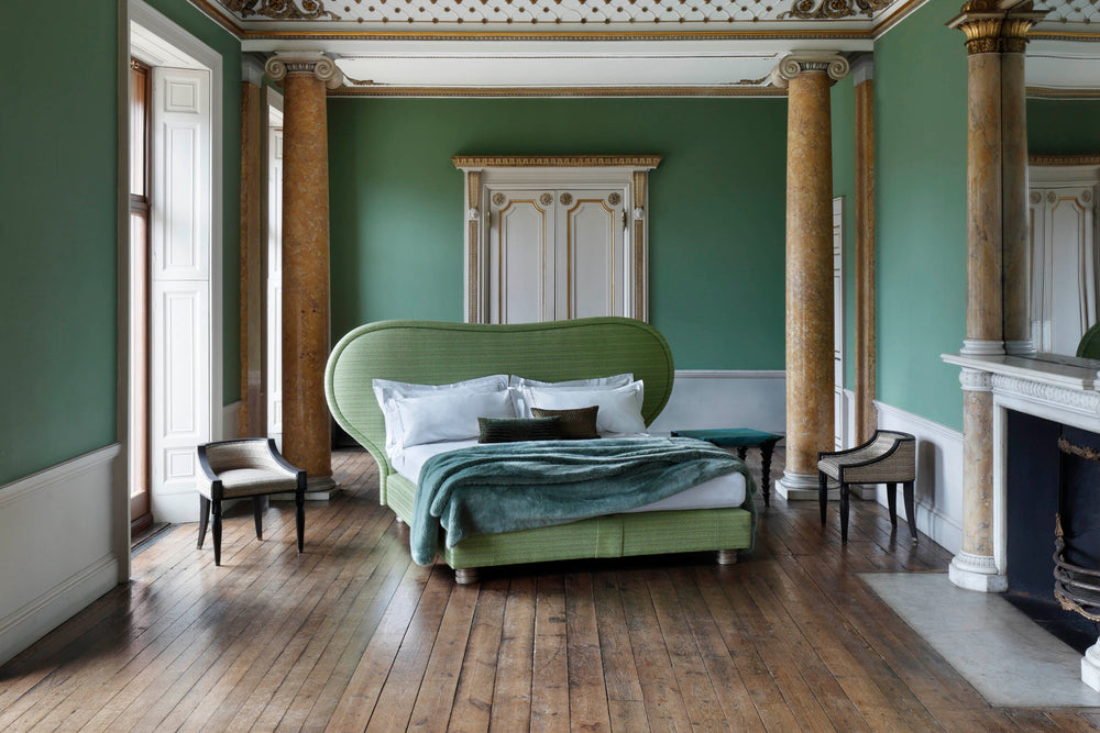 Focus on the Louis bed by Francis Sultana in a room with a green wall