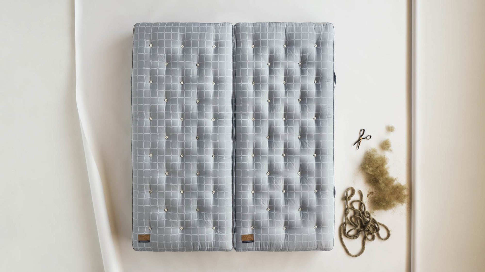 Image of a Savoir mattress laid on the floor with its ingredients next to it.