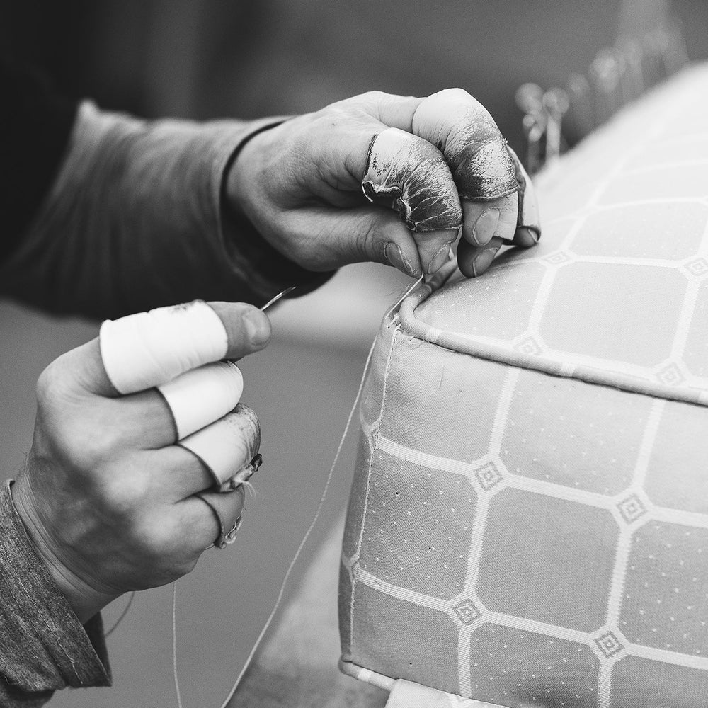 A craftsman hand stitches a Savoir mattress closed, allowing opulent amounts of horse hair to be inserted to elevate comfort and longevity