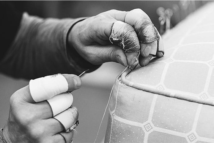 Closeup picture of craftsman stitching a side mattress