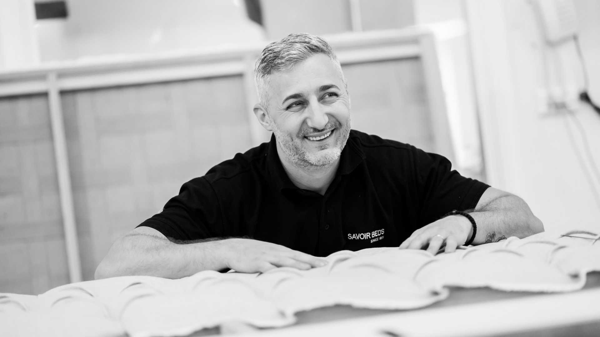 Black and white picture of a Savoir craftsman smiling