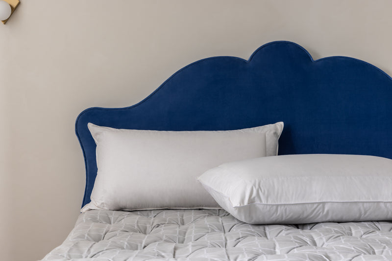 TWO WHITE PILLOWS AGAINST A BLUE 