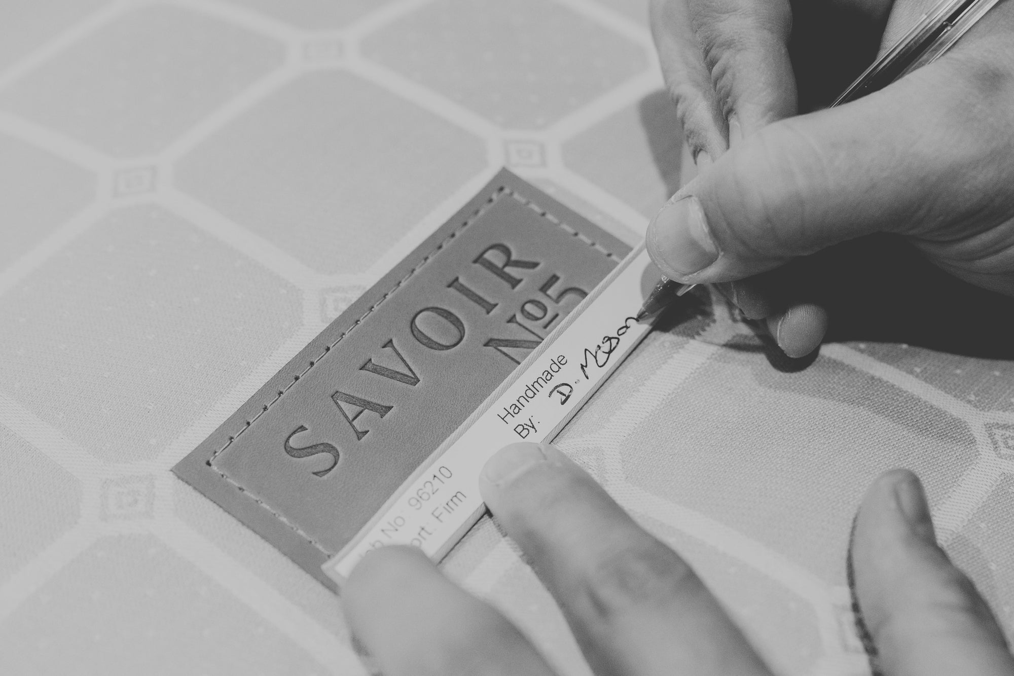 A craftsman signing by hand a Savoir No5 label