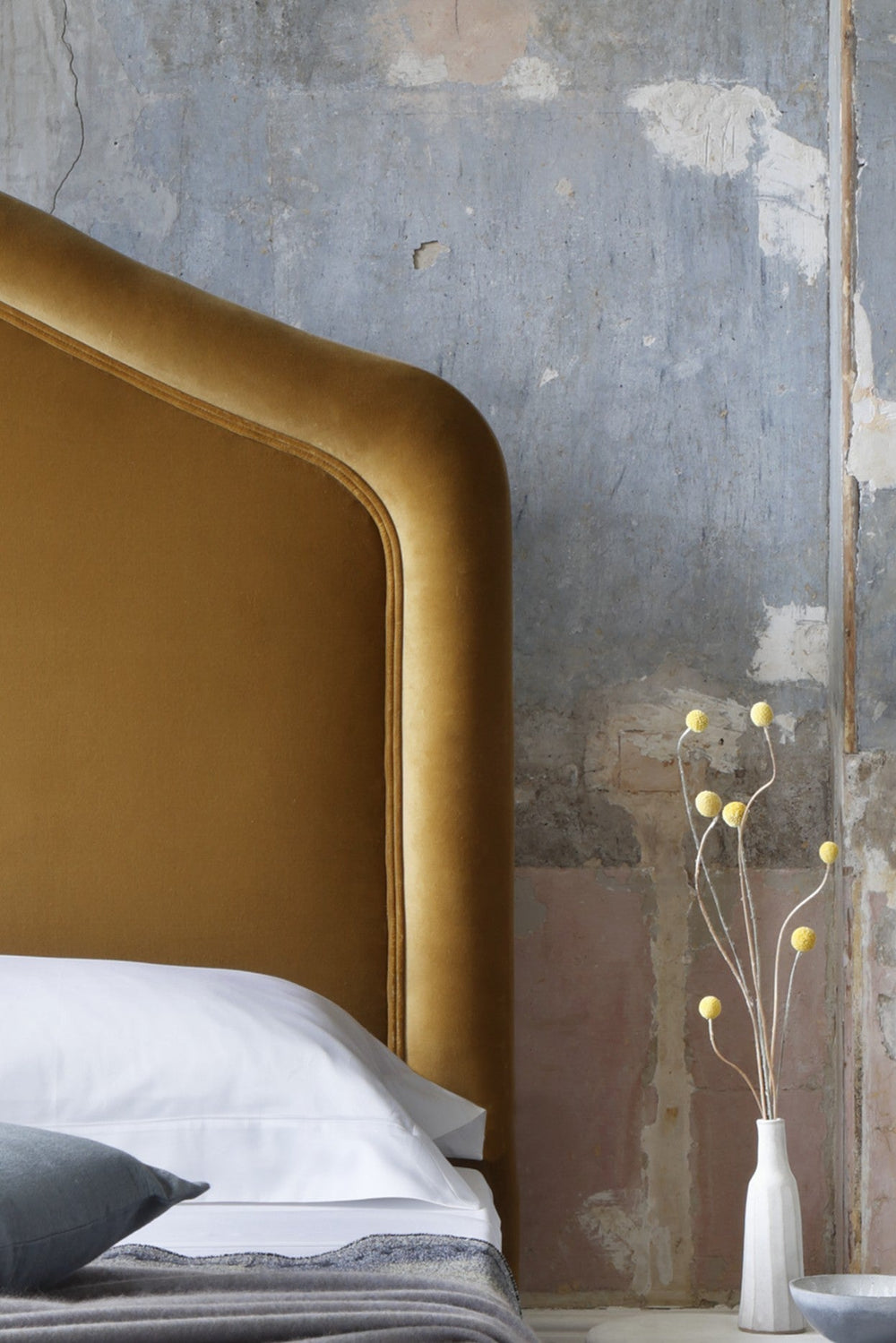 A close-up of the Savoir Cassie headboard upholstered by hand