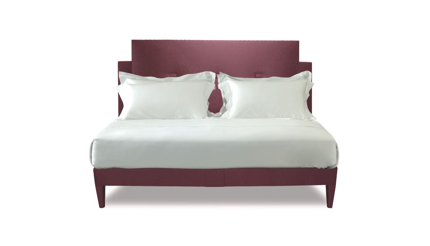 Undressed Savoy bed with red and pink tints headboard and base featuring a mattress and cushions