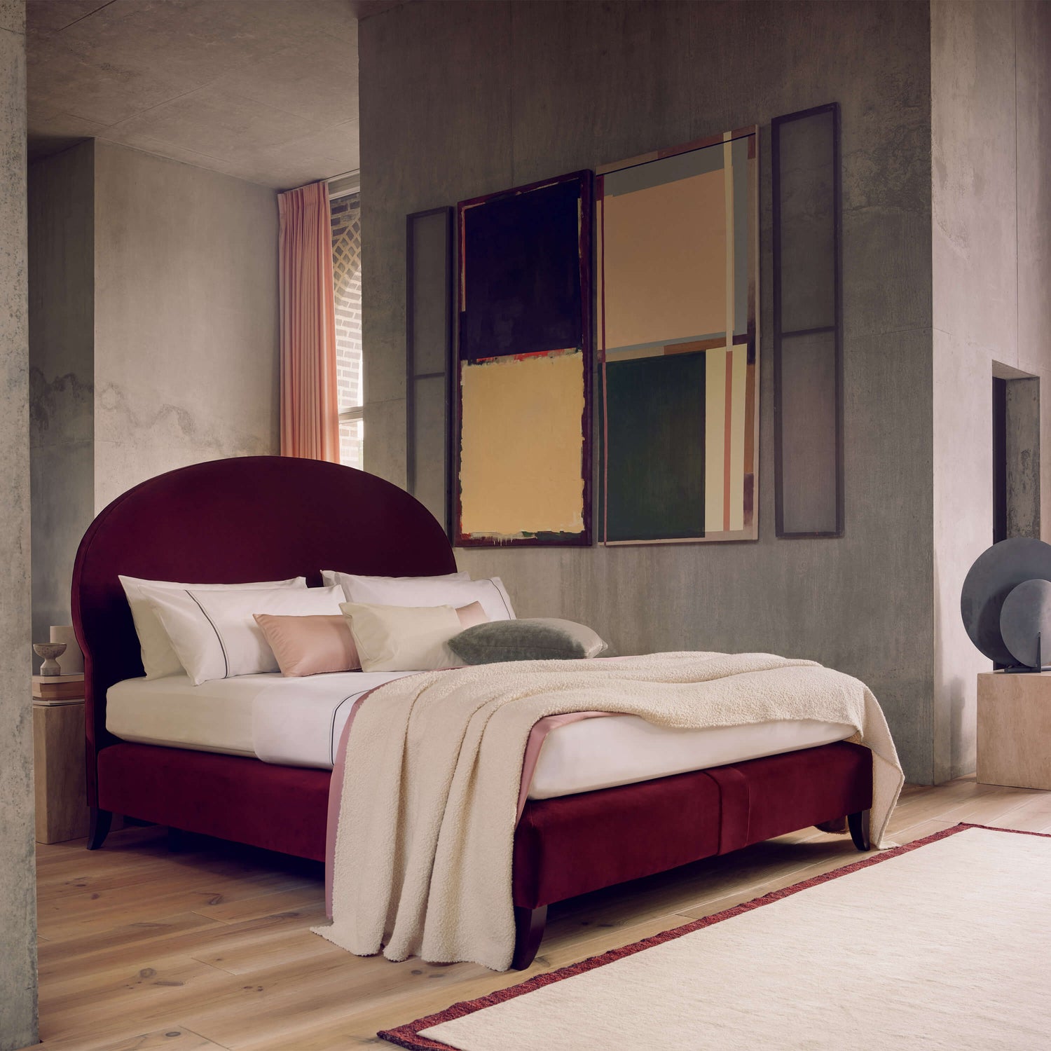 Savoir Elly bed with burgundy headboard and base completely dressed and set in a room