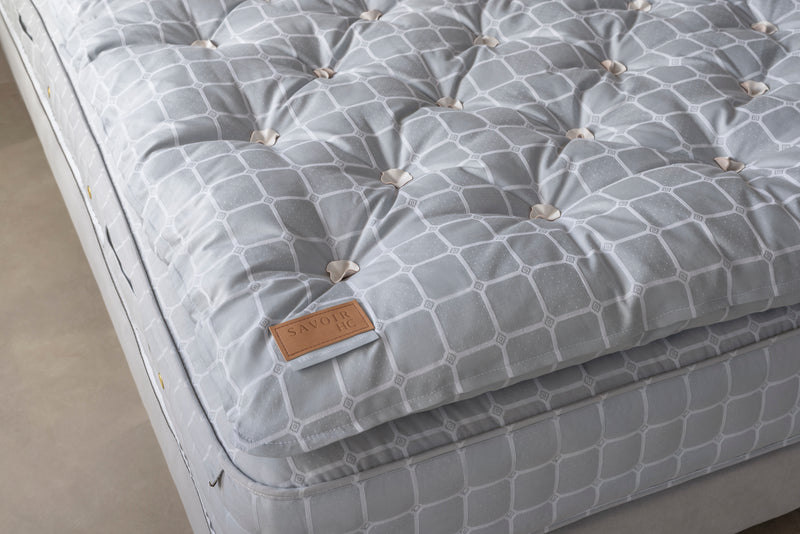 Corner of a Savoir HC topper on grey mattress