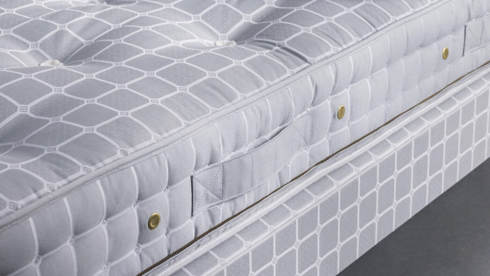 Side view of a Savoir No5 mattress with handle and base