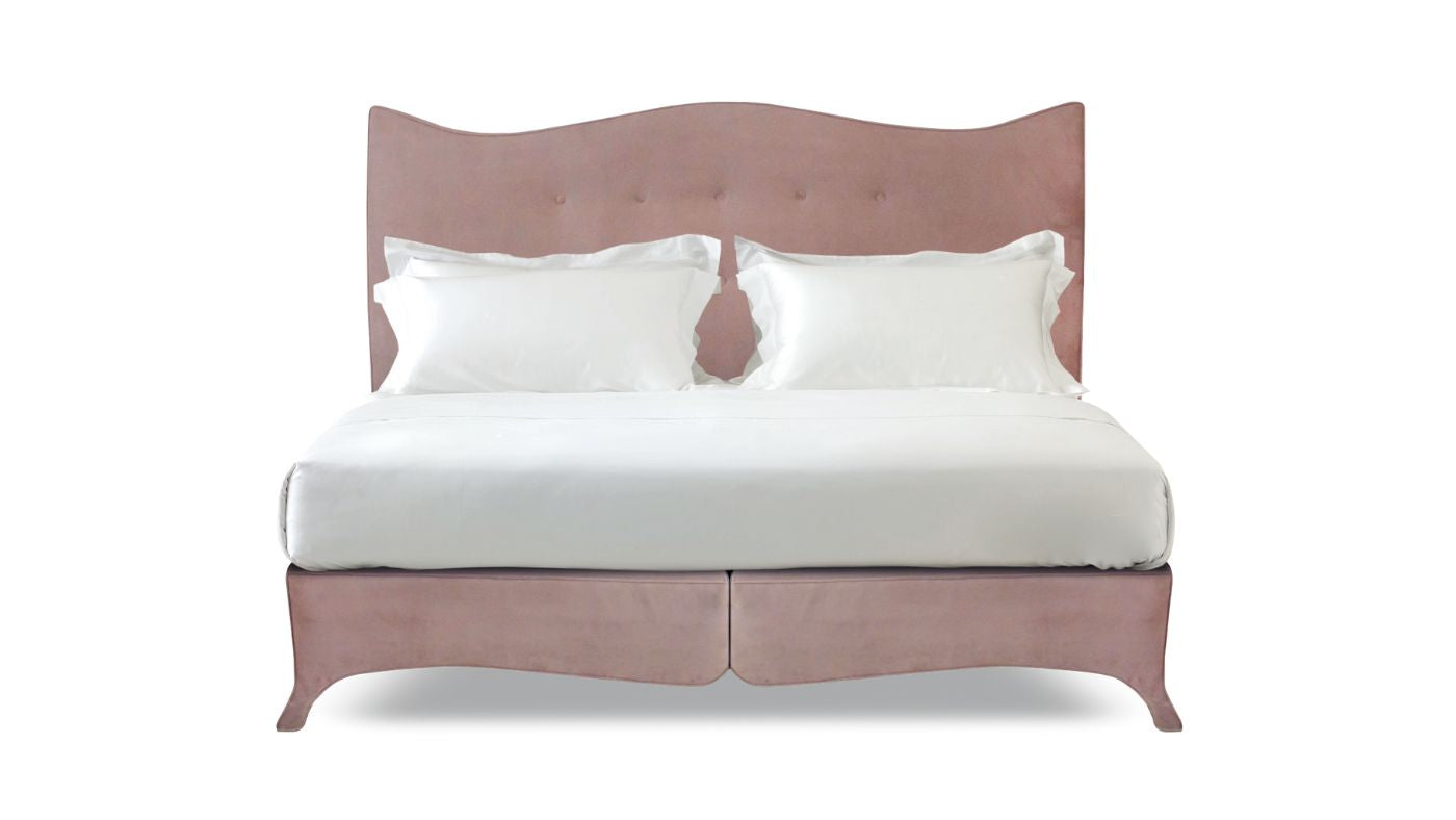 Undressed Penelope bed with a light pink headboard and base featuring a mattress and cushions