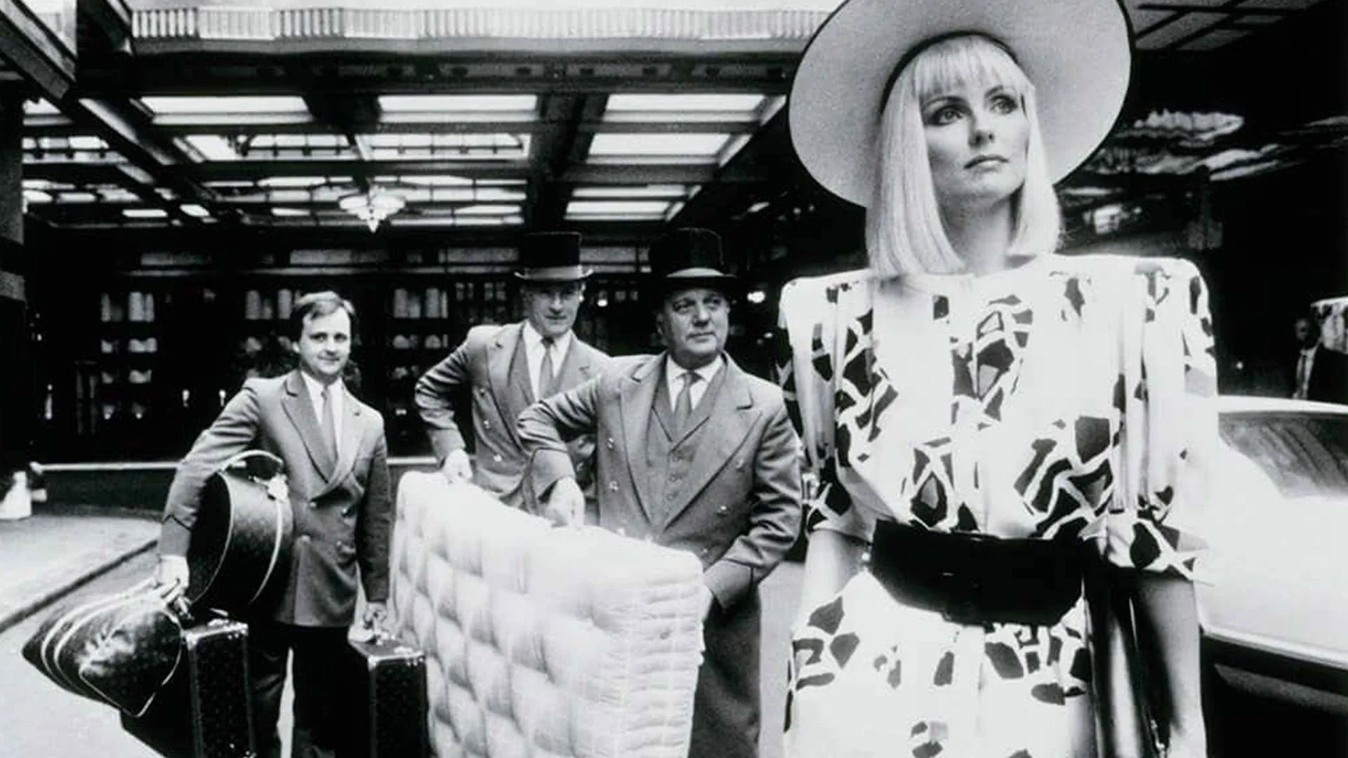 Black and white picture featuring Savoy hotel employee carrying a Savoir mattress