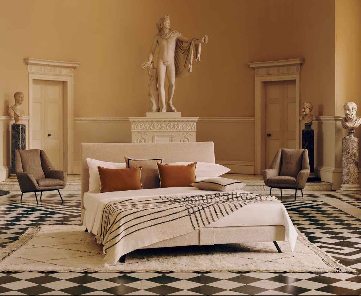Stately bedroom with Ian bed and classical statues and decor