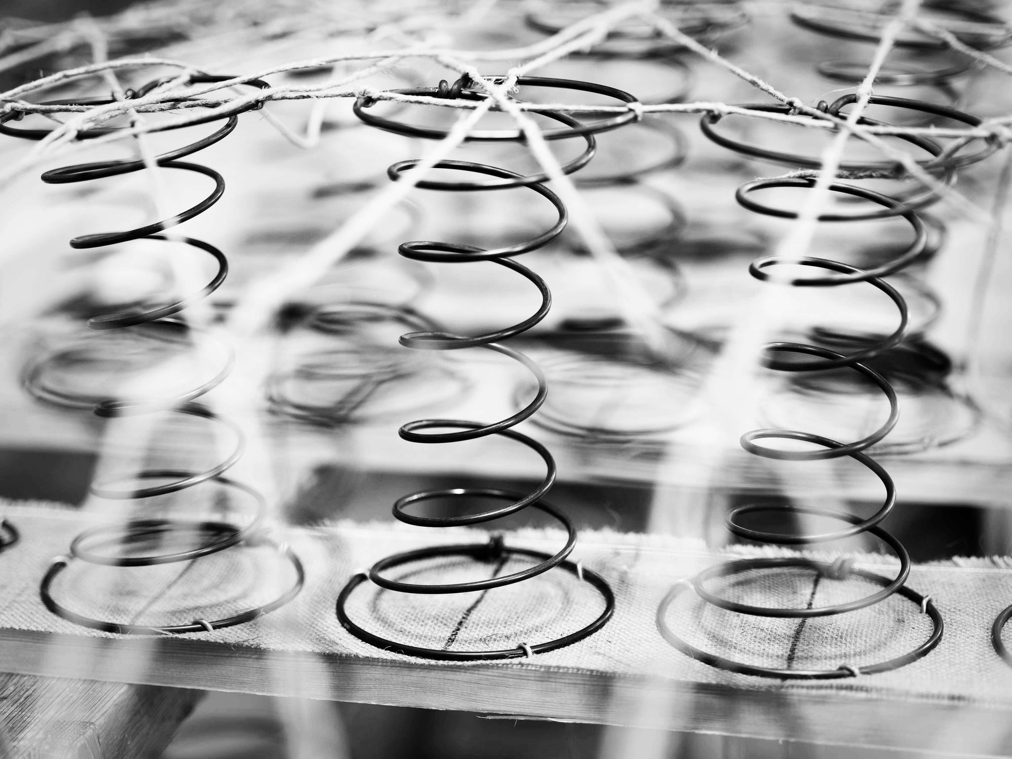 Hourglass springs that are used in our box spring bases, hand-tied for better longevity and comfort, tailored to your tension preference.
