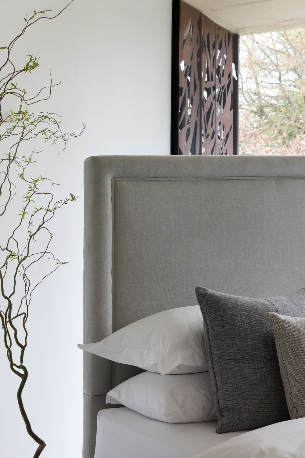 Close-up of the Savoir No4 Reformer headboard upholstered in linen.