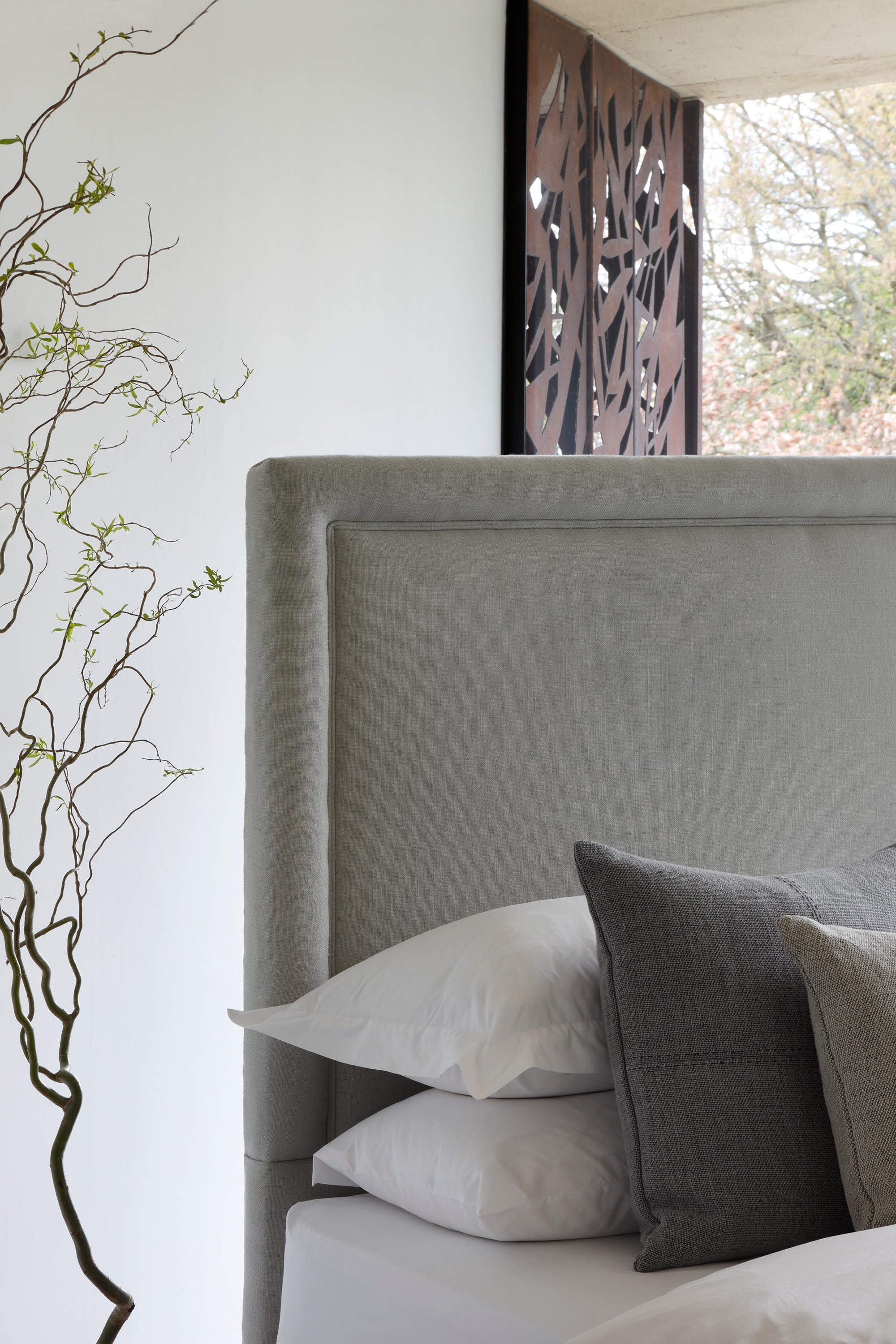 Close-up of the Savoir No4 Reformer headboard upholstered in linen.