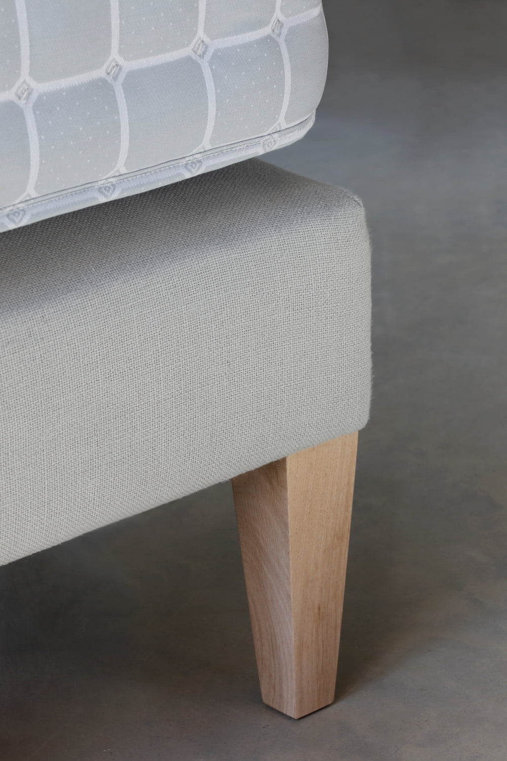 Close-up of the Savoir No4 Reformer leg and base upholstered in linen.