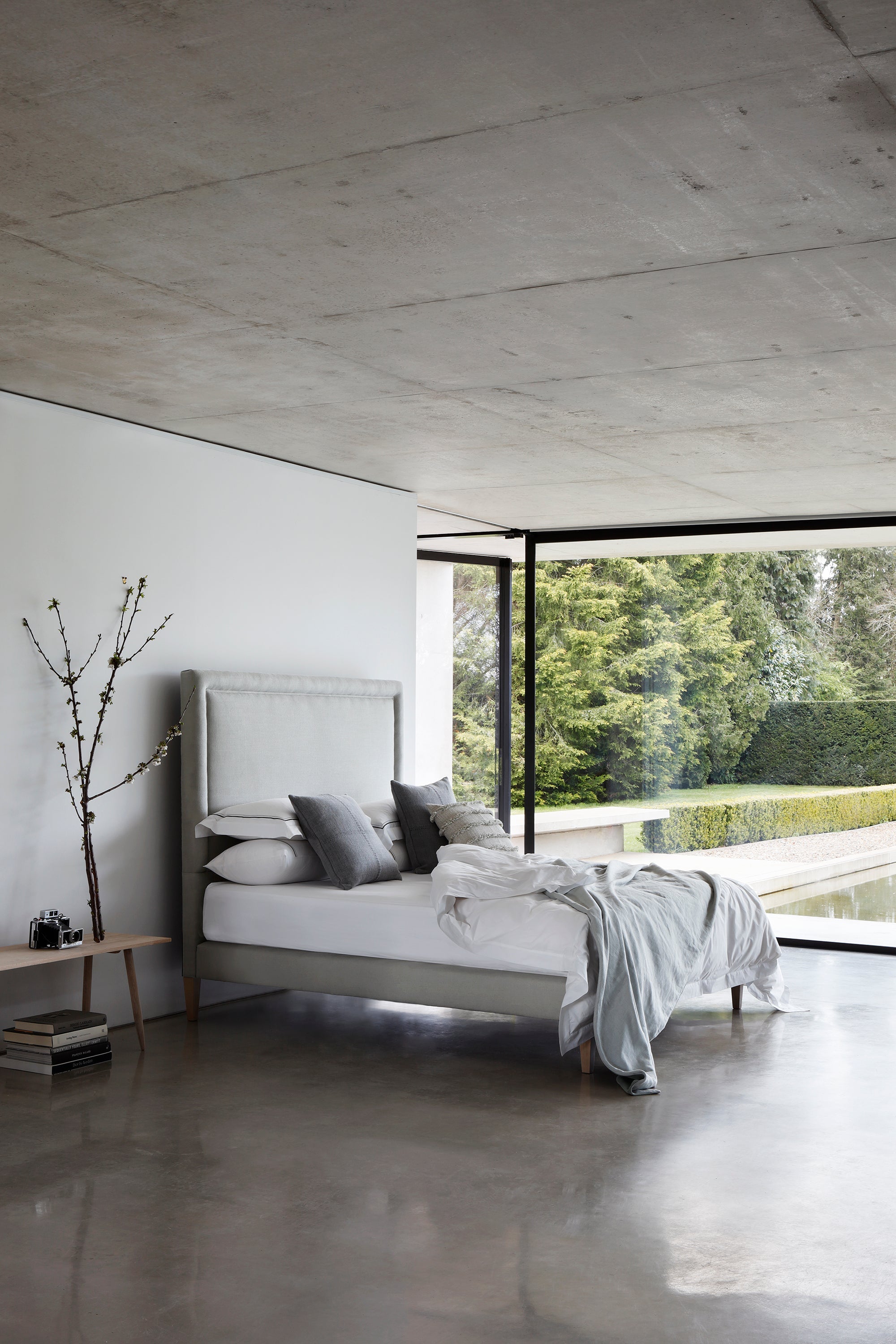 Side view of the Savoir No4 Reformer bed with headboard and base upholstered in linen.