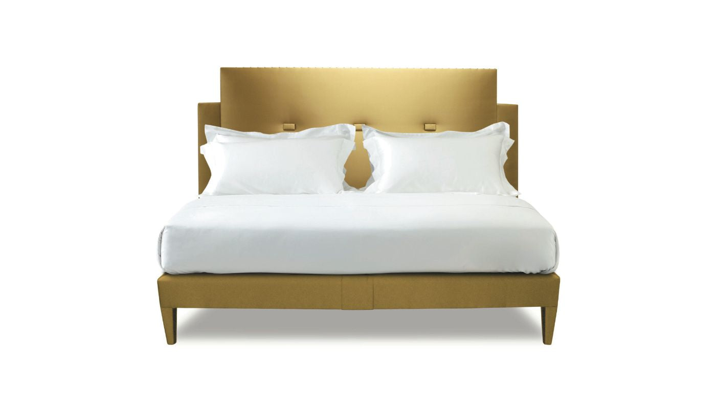 Undressed Savoy bed with a gold colour headboard and base featuring a mattress and cushions