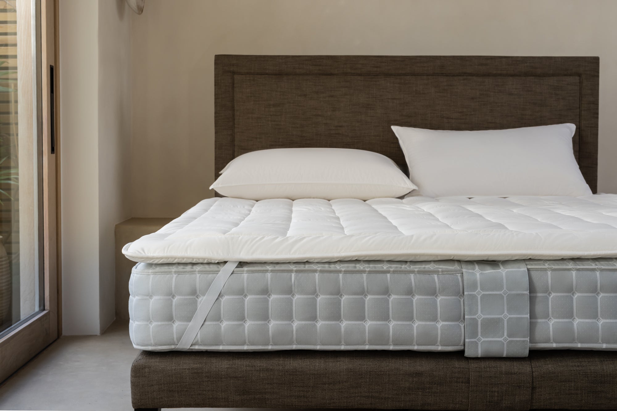 Luxury mattress protector secured to a Savoir mattress with elastic strap